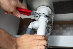 Person tightening a leaking pipe